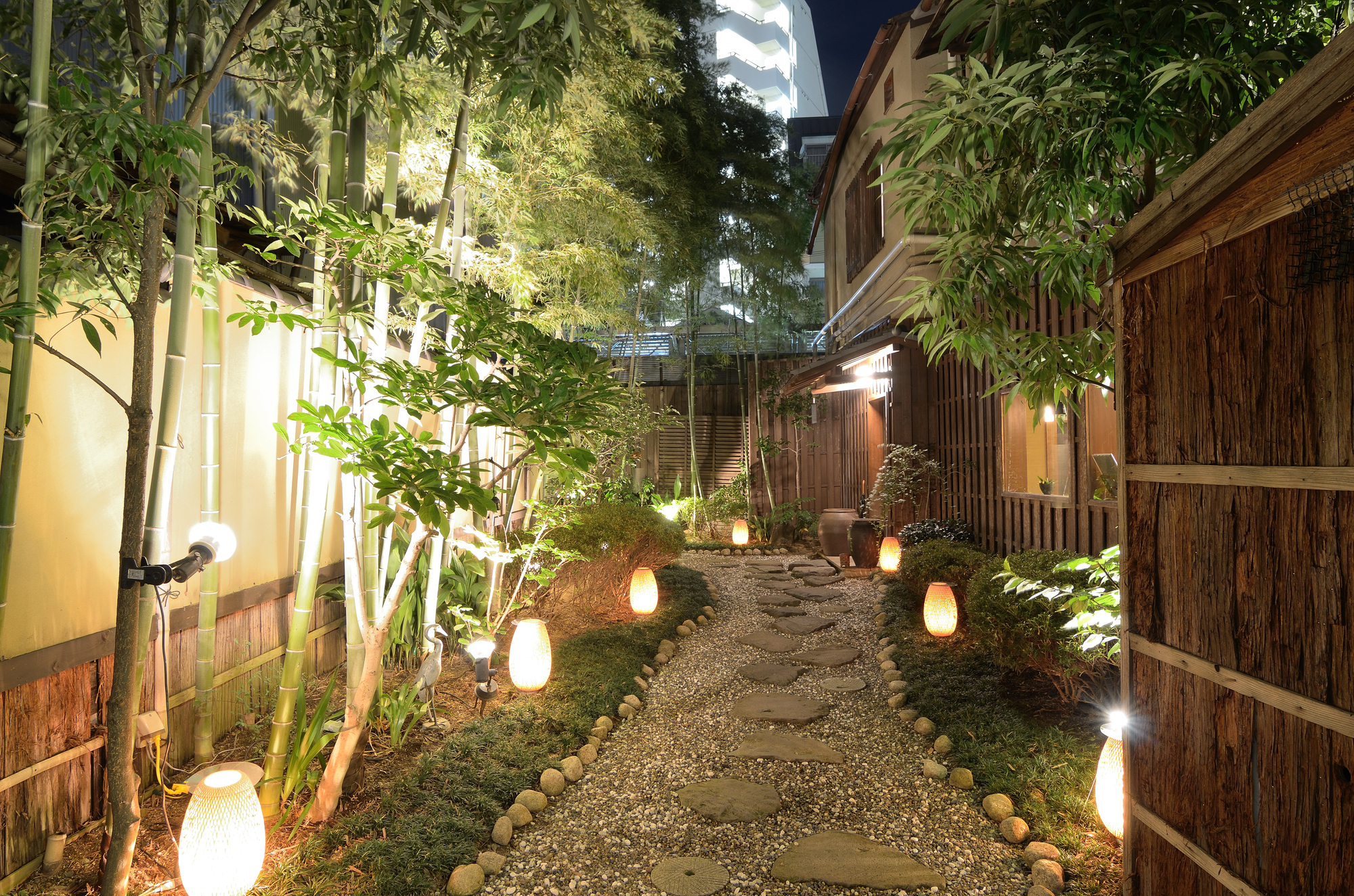 gravel walkway next to fence with pathway lighting